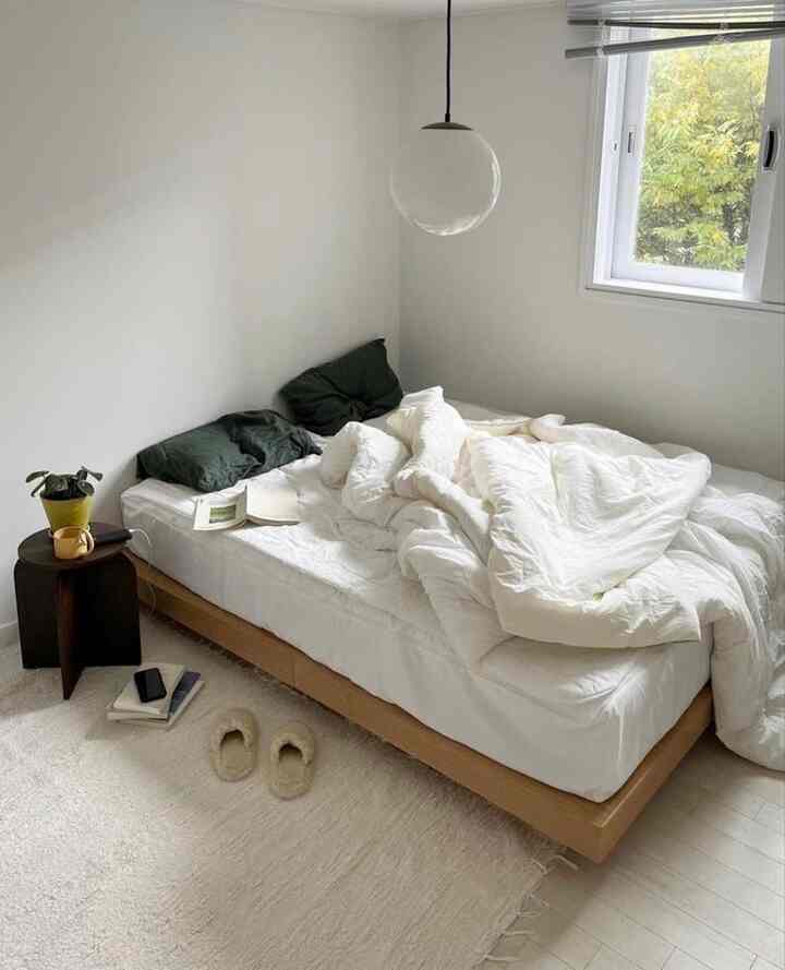 白とナチュラルカラーの寝室、低いベッドとシンプルで落ち着いた雰囲気のインテリア