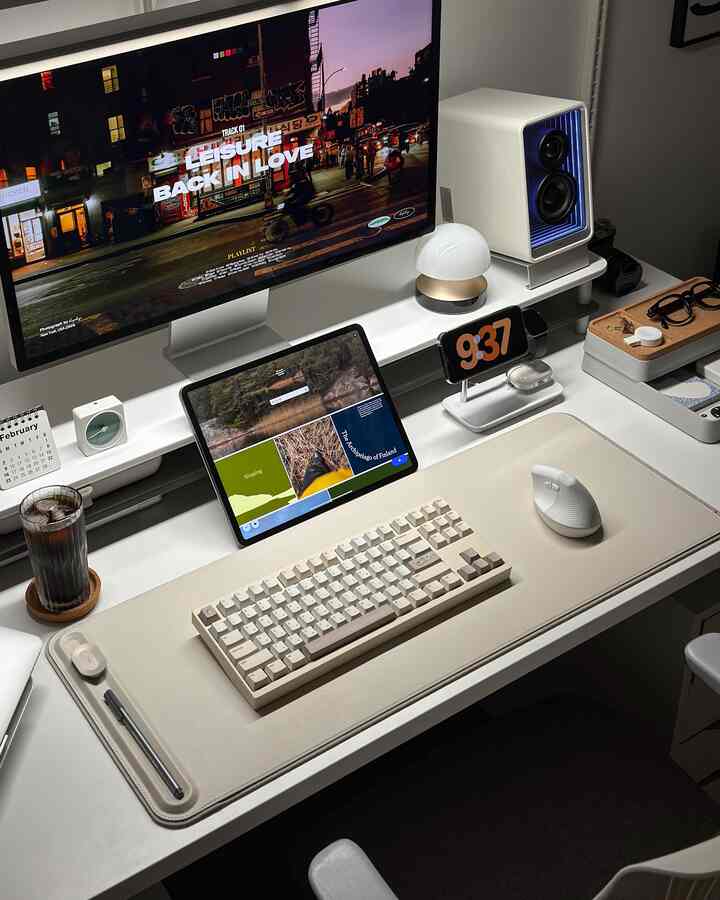 白とグレーのトーンでまとめられた清潔感あるホームオフィスデスク、キーボードとマウス、モニター、スピーカーが配置された現代的な作業空間