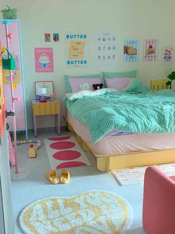 パステル調のグリーンストライプ寝具、ぬいぐるみとカラフルなポスターが配置された雰囲気のある寝室