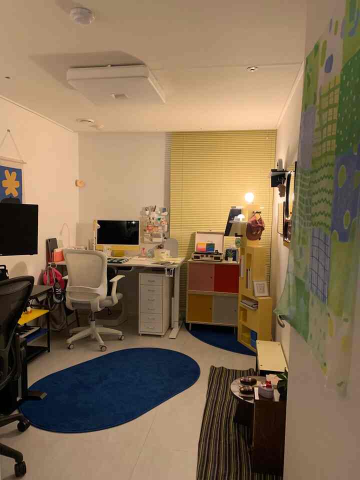 黄色と青のアクセントが効いたモダンでシンプルな二人暮らしのホームオフィス、整然とした家具配置が印象的な空間