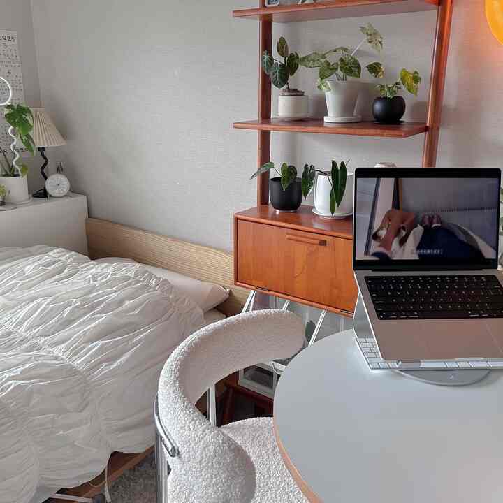 Natural modern bedroom with white and brown tones, featuring a round table and white fabric chair in a cozy atmosphere