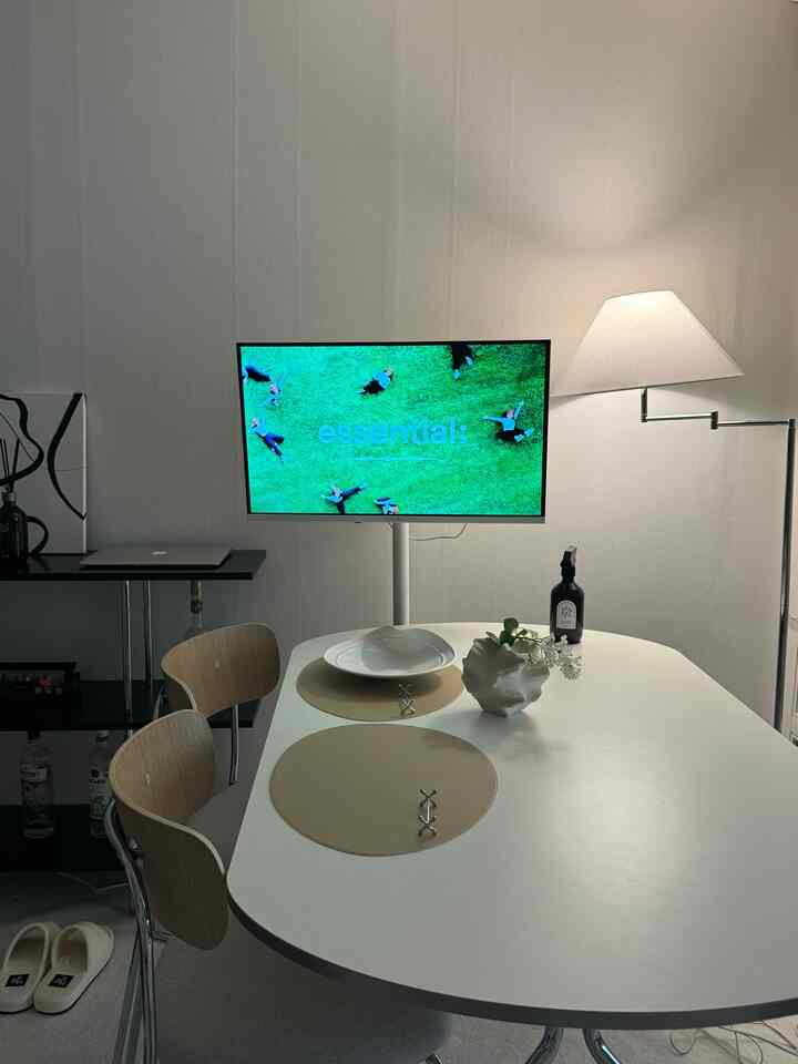 白とベージュのトーンのダイニングルーム、シンプルでモダンなテーブルと椅子、フロアランプが配置された落ち着いた空間