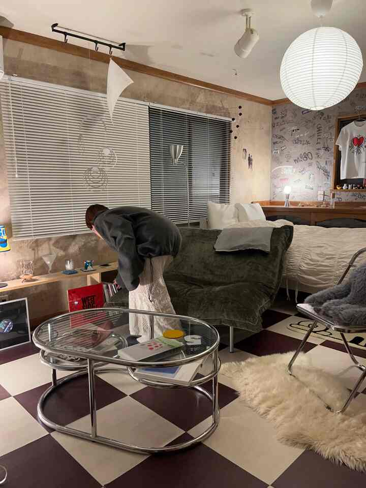 ヴィンテージとミッドセンチュリーモダンが調和したリビング、チェック柄フロアと多様な照明が配された雰囲気のある空間