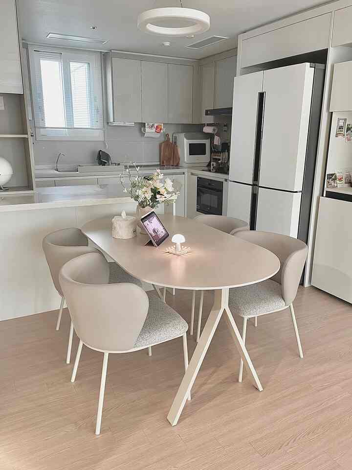 ナチュラルモダンスタイルのコンパクトなキッチン、ベージュの4人用ダイニングテーブルが配置された落ち着いた空間