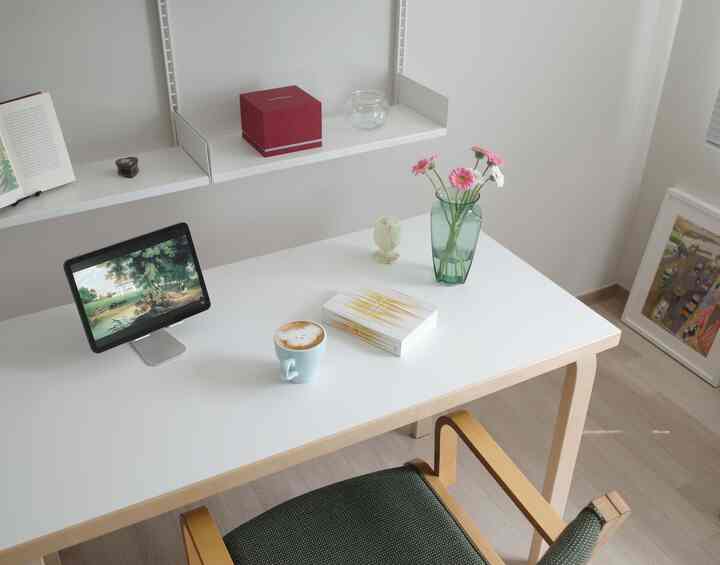 白と木目調の調和が取れた6畳のホームオフィス、机の上にタブレットと花瓶、コーヒーカップが置かれたミニマルな空間