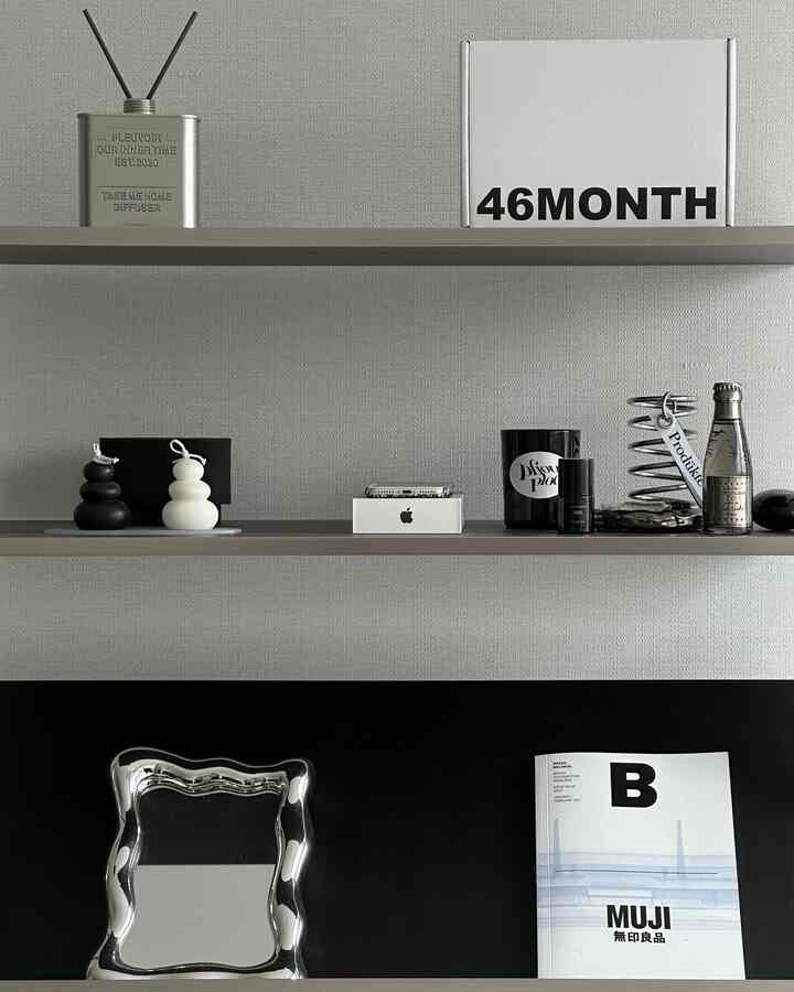 Monotone wall and shelves in a minimalistic interior featuring a diffuser and various small decorative items neatly arranged on the shelves