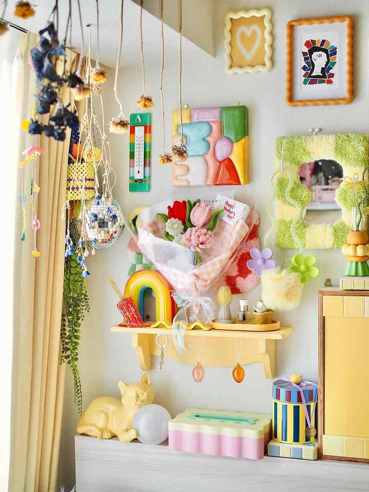 明るい黄色調でカラフルなウォールアートと花束が配置された、雰囲気のある寝室インテリア