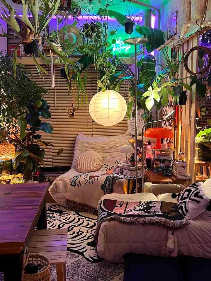 暖色系の居心地の良いリビング、豊かな植物と快適なソファ、ペンダントライトが温かい雰囲気を演出するインテリア