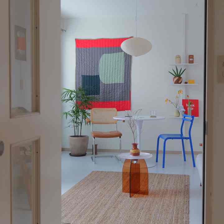 白とナチュラルカラーが調和した二人暮らしのダイニング、印象的なウォールアートとペンダントライトが配置された雰囲気のある空間