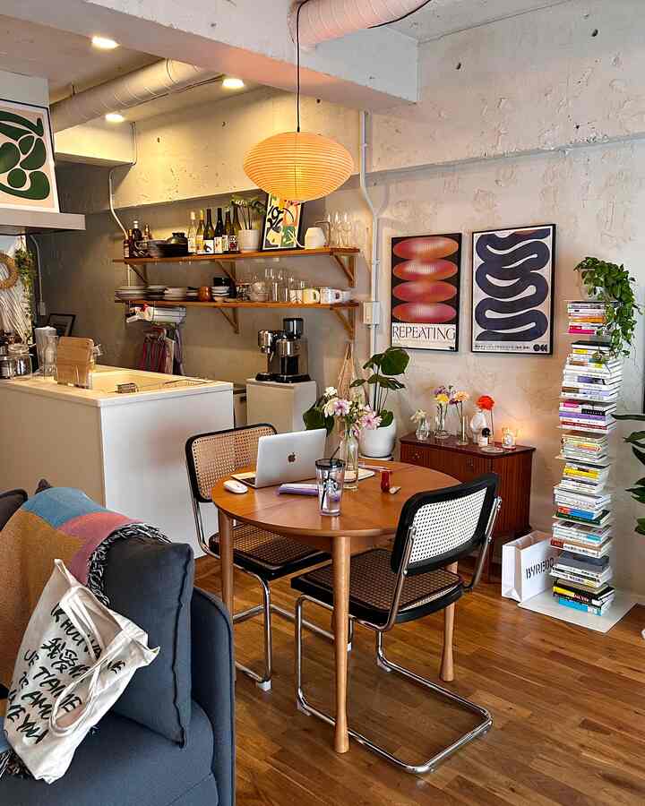 暖かい木目調とナチュラルな雰囲気のリビング、丸テーブルと花瓶が配置されたモダンで居心地の良いインテリア