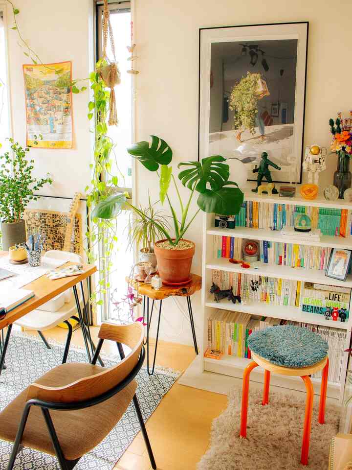 明るい木目調の1LDKリビング、ダイニングテーブルと本棚、観葉植物が配置されたミッドセンチュリーモダンな雰囲気のインテリア