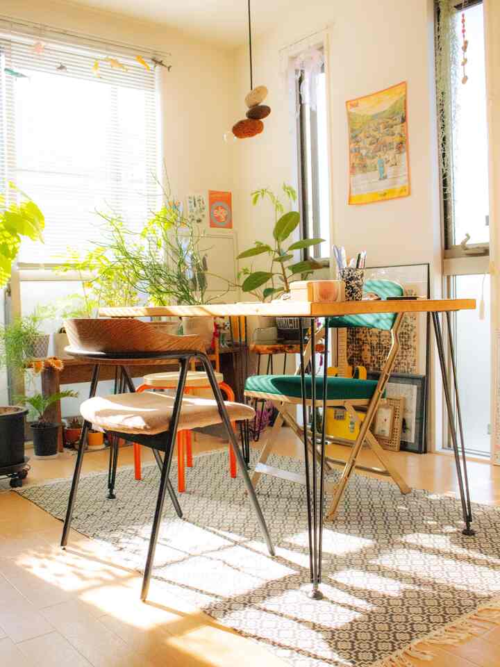 温かみのある木目調と緑の植物が調和する1LDKのダイニング、ミッドセンチュリーモダンの雰囲気あるインテリア