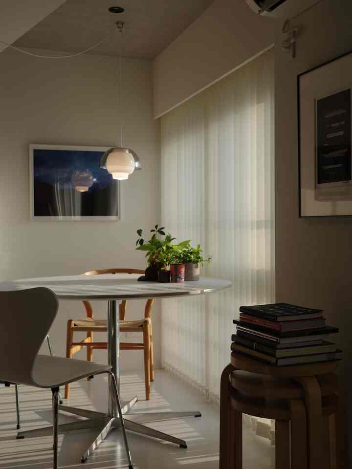 White-toned dining room featuring a central round table and Nordic furniture with a calm, refined atmosphere