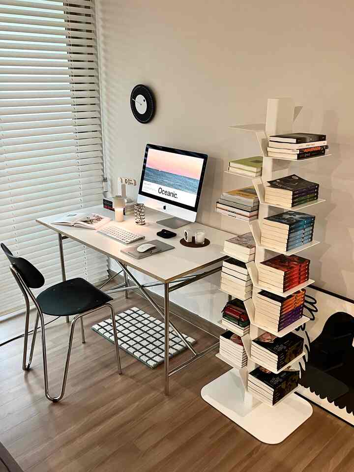 ホワイトと木目調が調和した北欧風のホームオフィス、机と椅子、書棚が配置されたミニマルな空間