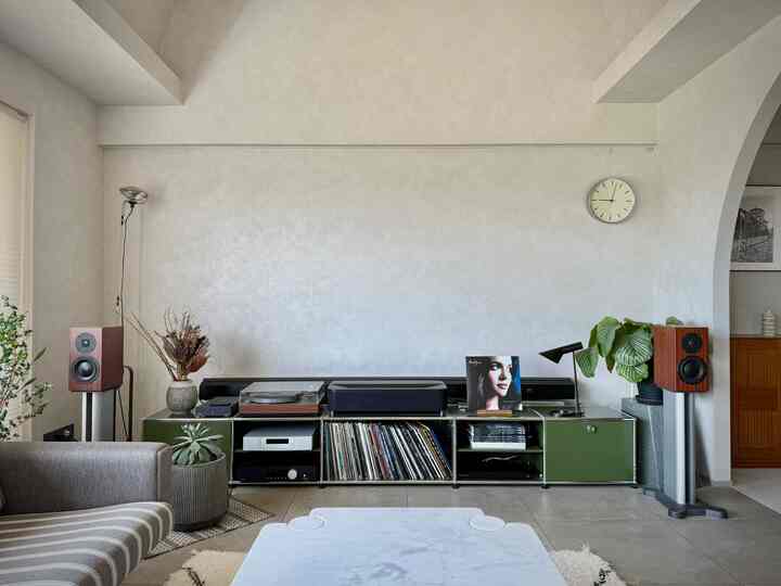 Minimal living room with white and green tones, featuring vintage LP turntable and speakers for a retro atmosphere