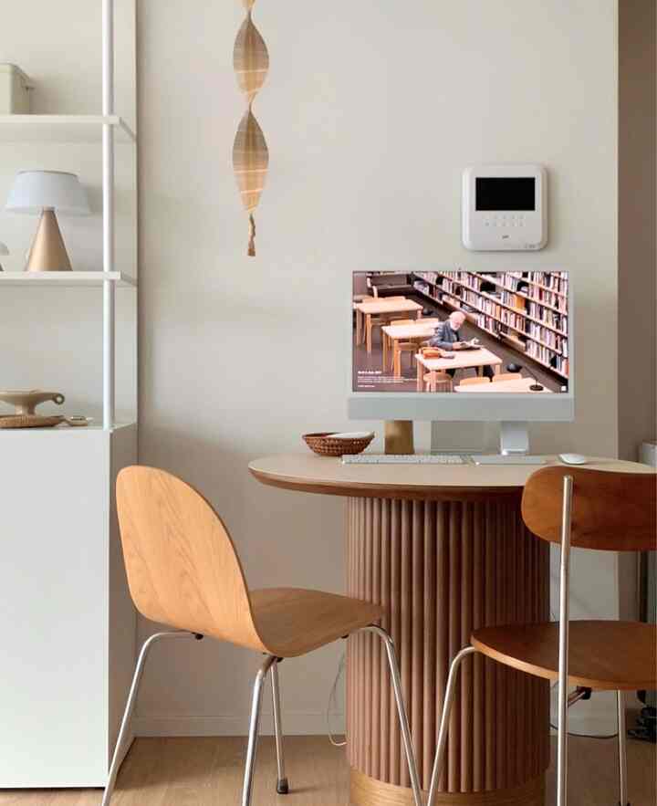 白い壁と木目調の家具が調和するミニマルなホームオフィス空間、2脚の木製椅子が配置された落ち着いた作業環境