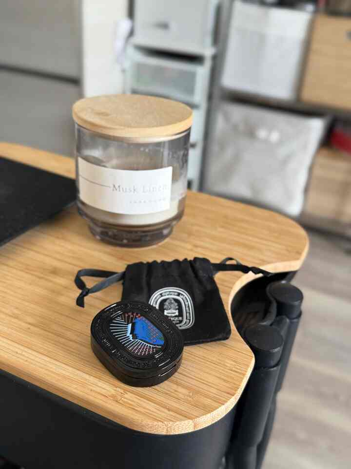 木目調の小さな空間にキャンドルとディプティックの香水が置かれた、落ち着いた雰囲気のインテリア