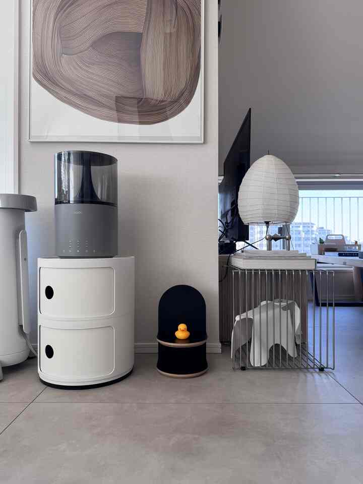 白とグレーのトーンが特徴のリビング、ミッドセンチュリーモダン家具とフロアランプが配置された雰囲気のあるインテリア