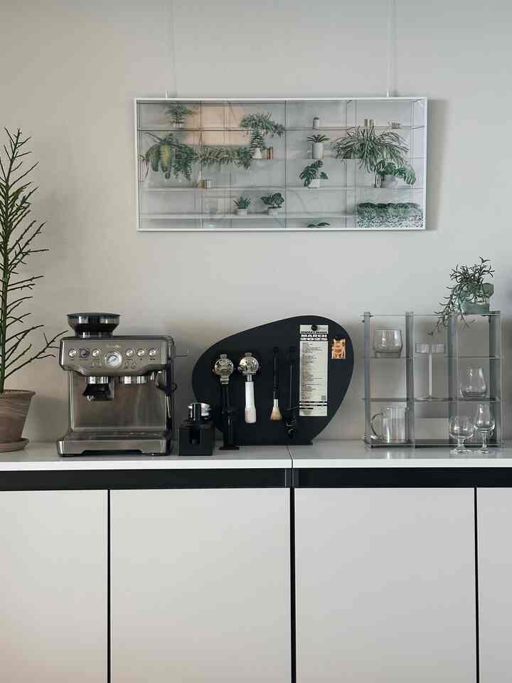 黒と白のトーンのホームカフェ空間、ブレビルのエスプレッソマシンと植物が調和したシンプルで実用的なインテリア