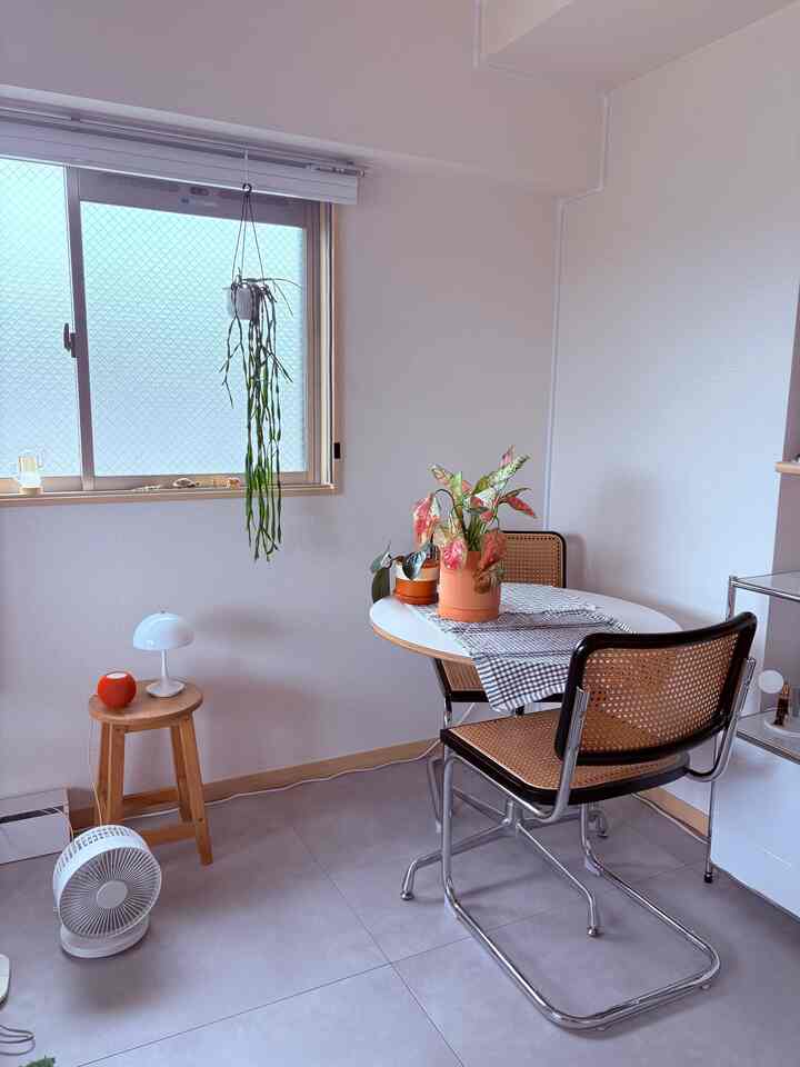 柔らかなナチュラルカラーのリビング空間、丸いダイニングテーブルとラタンチェアが配置された雰囲気のあるインテリア