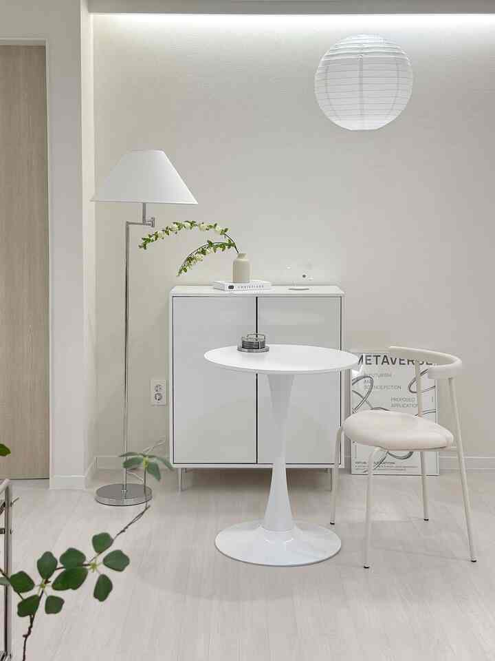 明るいホワイトトーンの廊下、ミニテーブルと収納キャビネットが整然と配置されたおうちカフェの雰囲気