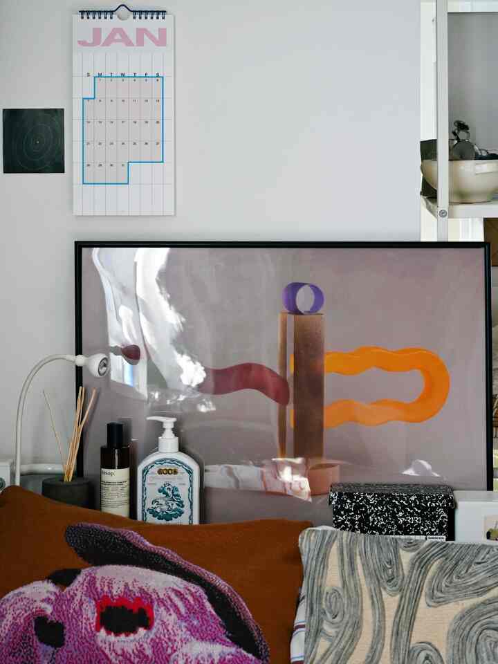 White and brown toned bedroom featuring a large poster and cushions with a cozy atmosphere