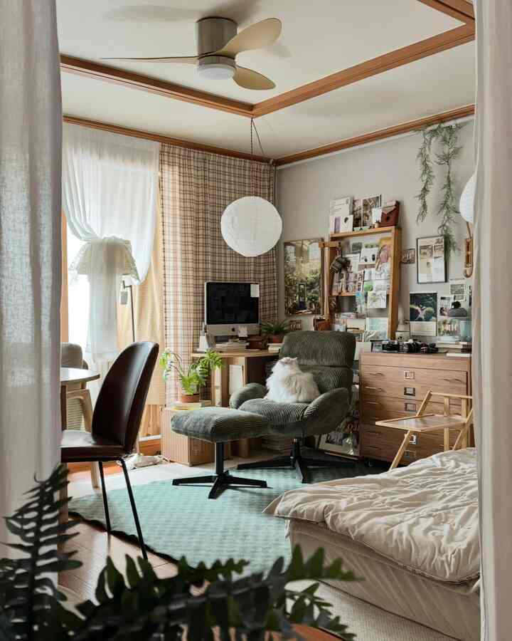 ウッドトーンとブラウンのホームオフィス空間、ヴィンテージのアームチェアと机が配置され、白い猫がいる温かみのある部屋