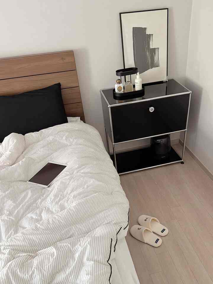 White and natural color bedroom featuring modern nightstand and tidy bedding, creating a cozy atmosphere