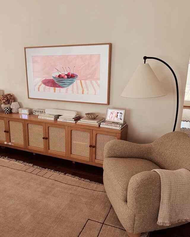Beige and brown toned living room featuring a cozy armchair, sideboard, and floor lamp with a natural and simple atmosphere