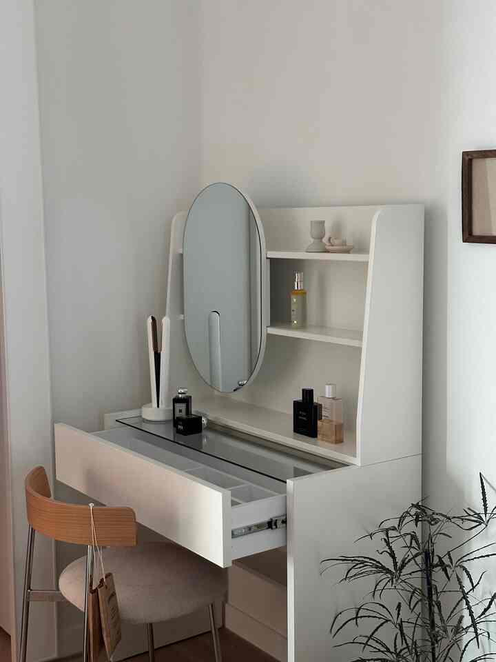 白を基調としたモダンなワンルーム、シンプルで整然とした化粧台と椅子が配置された雰囲気のあるインテリア