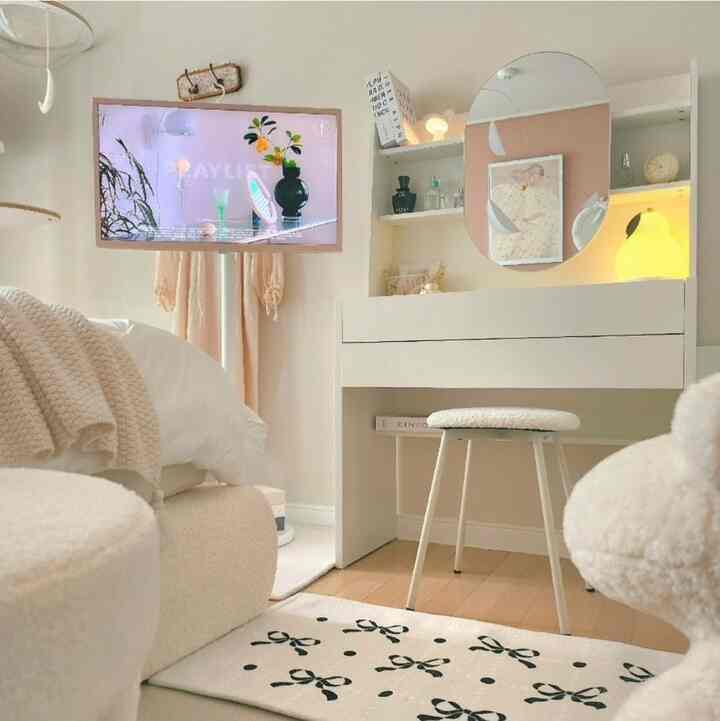 白とベージュのトーンのワンルーム寝室、スライディングミラー付きの収納化粧台が配置された柔らかくミニマルな雰囲気のインテリア