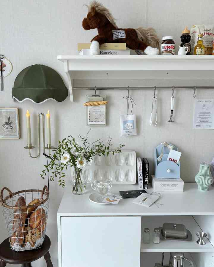白を基調としたキッチンスペース、棚と収納家具が配置されたナチュラルで整った印象的なインテリア