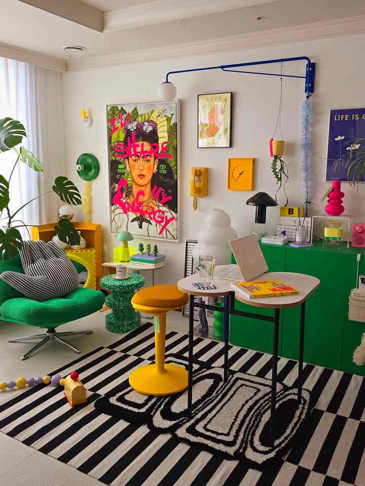 明るい黄色と緑を主調としたリビング、黄色のスツールと緑のアームチェアが映えるカラフルな空間
