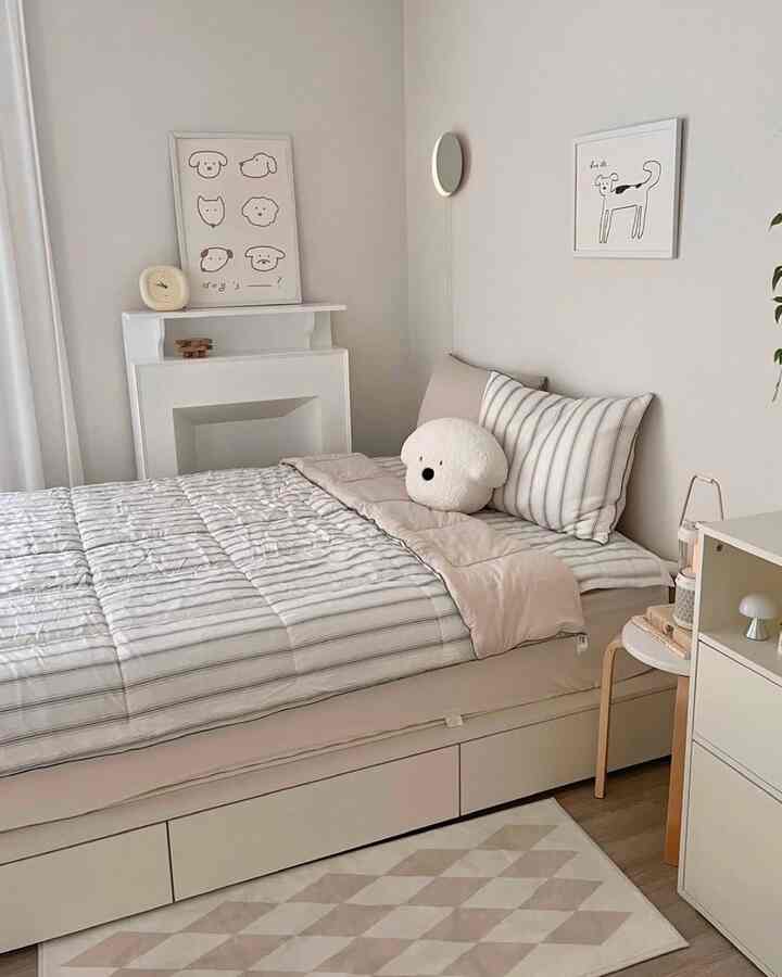 ベージュとホワイトの色調の寝室、ベッドと犬の形のクッション、ポスターが配置されたシンプルでナチュラルなインテリア