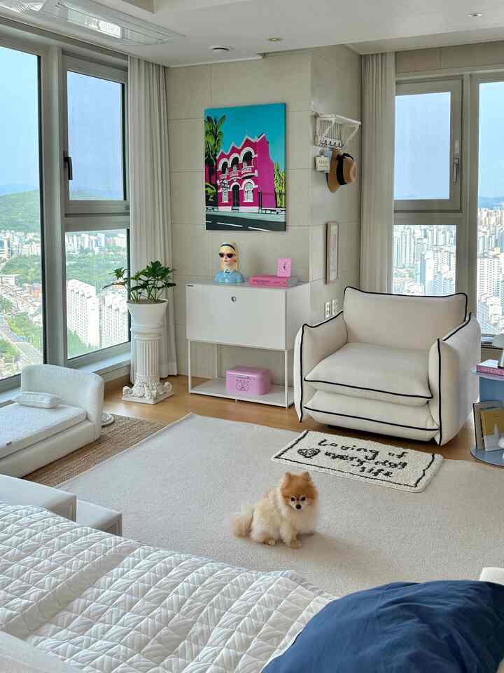 Beige and white toned living room featuring a cozy recliner and bean bag, with a small dog and pet accessories creating a warm atmosphere