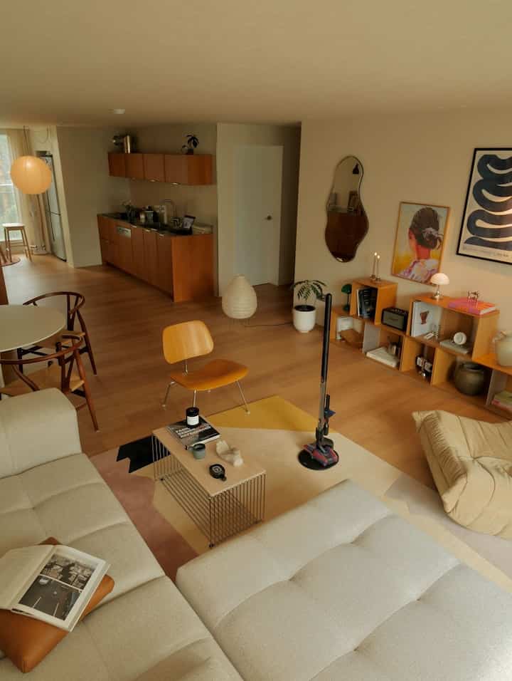 ベージュとナチュラルトーンのリビングダイニングルーム、モダンな家具とテーブルランプが配置された雰囲気のあるインテリア