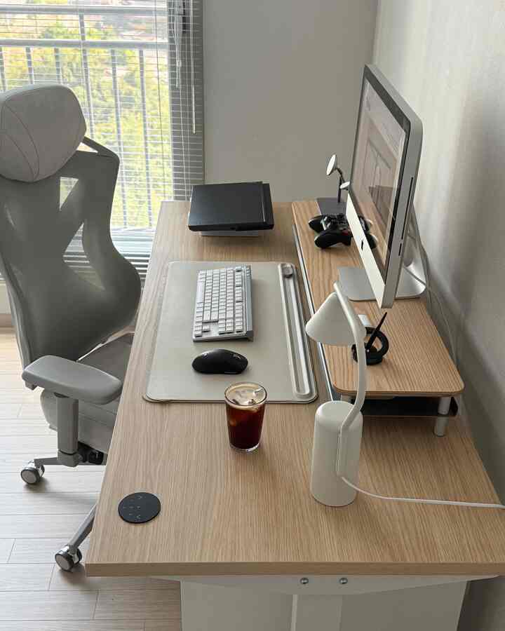 ホワイトと木目調が調和したコンパクトなホームオフィス、モニターとオフィスチェアが配置された機能的な空間