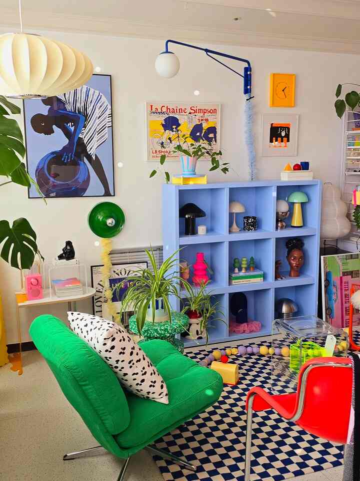 明るいグリーンとブルーのトーンのリビング、ミッドセンチュリーモダンの家具と活気あるアートが配置された印象的な空間