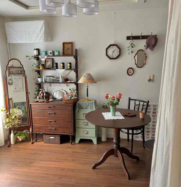 ナチュラルな木目調のダイニング、ヴィンテージ家具と小物が配置された雰囲気のある空間