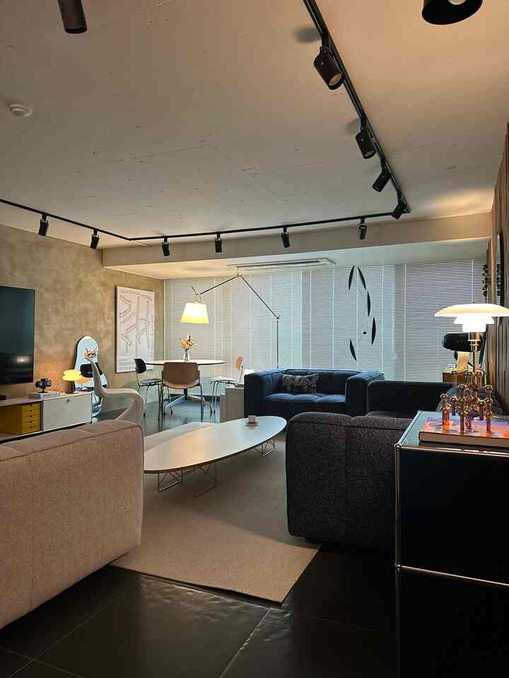 Modern living room in navy and beige tones featuring table lamps and a coffee table, creating a cozy atmosphere
