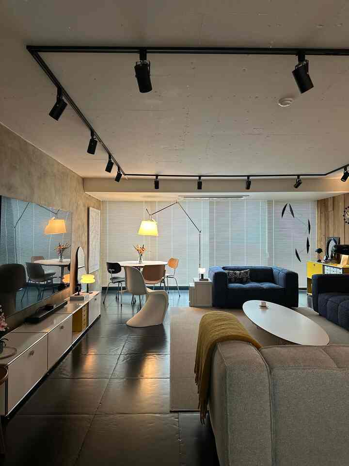 Modern living and dining room in gray and black tones featuring sofas, a coffee table, and a floor lamp in a stylish space