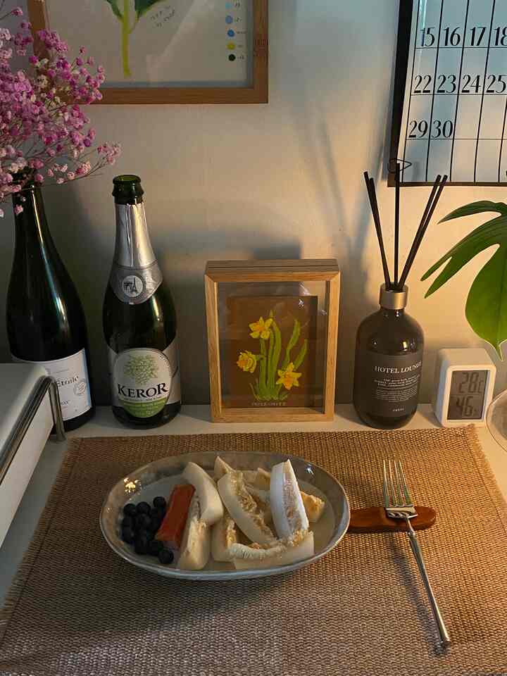 ナチュラルな木目調と植物のあるキッチン、皿とカトラリーが置かれた温かみのある朝食の空間