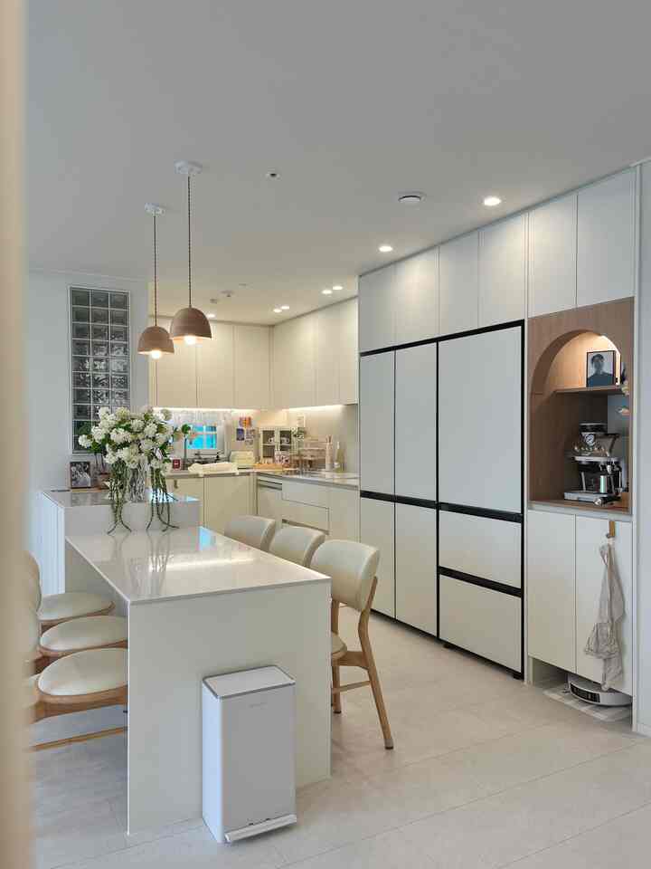 ホワイトと木目調が調和したモダンなダイニングルーム、アイランドダイニングテーブルとホームカフェコーナーが温かみのある印象的な空間