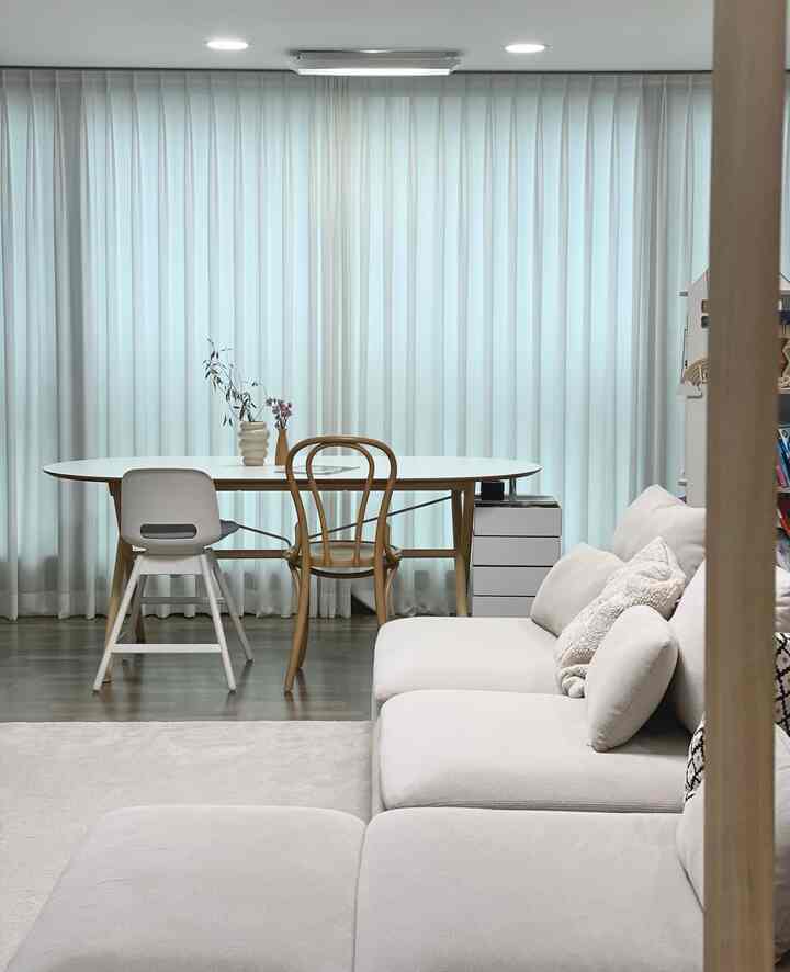 明るいアイボリー調のリビングダイニング、白いダイニングテーブルと木製チェア、ベージュのソファが調和したナチュラルな空間