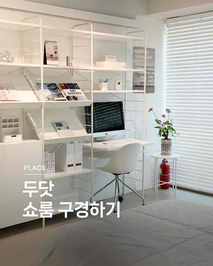 白を基調としたミニマルな書斎、白い棚とデスク、コンピューターが配置された清潔感のあるモダンなインテリア