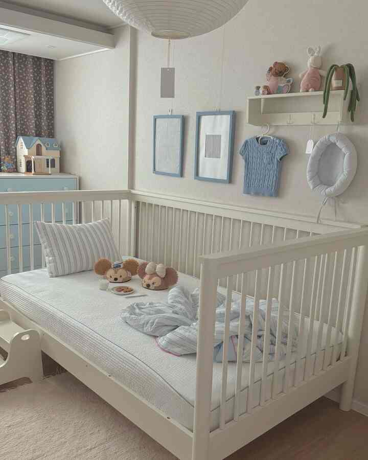 白とベージュのトーンのナチュラルモダンな赤ちゃんの寝室、ベビーベッドと収納棚が配置された印象的な空間