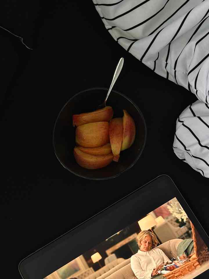 Monotone bedroom in black and white, cozy space featuring a black surface with a fruit bowl and striped bedding set