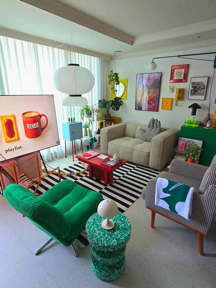 ホワイトトーンのリビング、ベージュのソファとグリーンのアームチェアが配置されたミッドセンチュリーモダンな雰囲気のあるインテリア