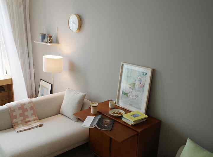 ナチュラルモダンのリビング、ベージュのソファと木製キャビネットが配置された居心地の良い空間