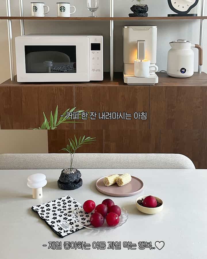 グレーとウッドトーンのキッチン空間、コーヒーマシン、電子レンジ、電気ケトルがウッドキャビネットに置かれたシンプルで自然な雰囲気のあるおうちカフェ